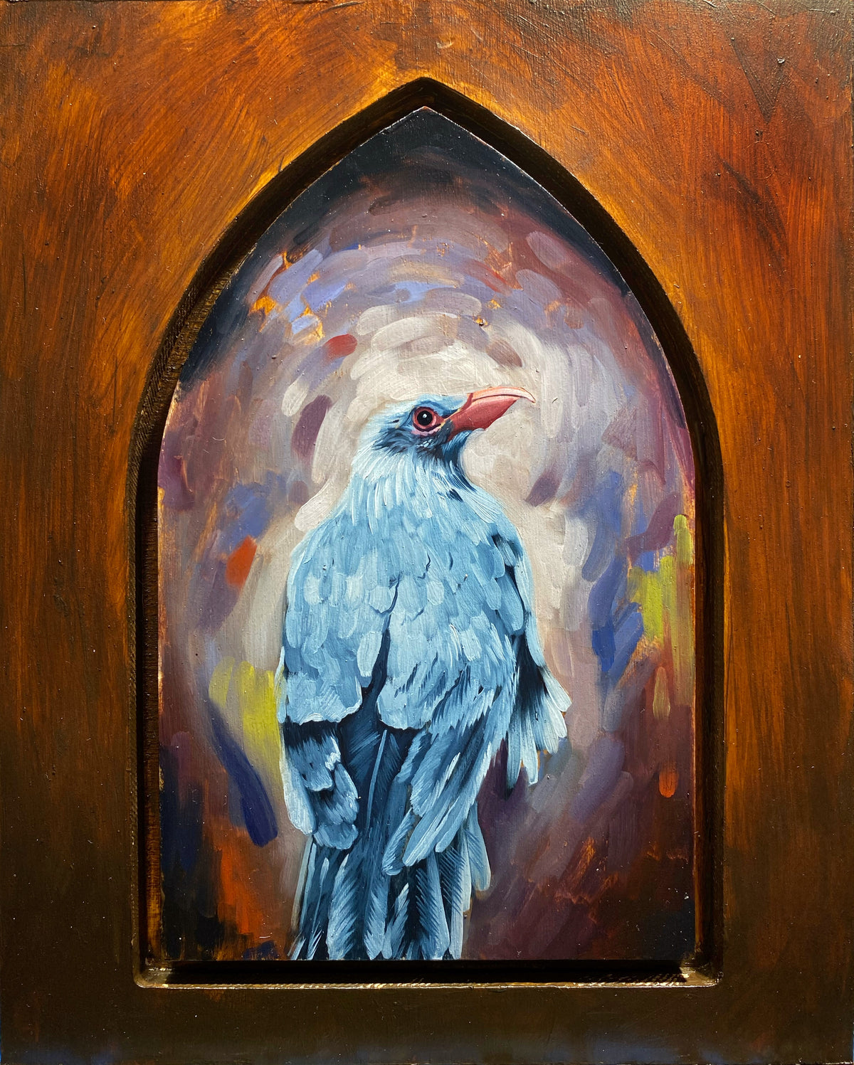 Blue bird with raised head painted inside a pointed Gothic arch, surrounded by warm orange tones.