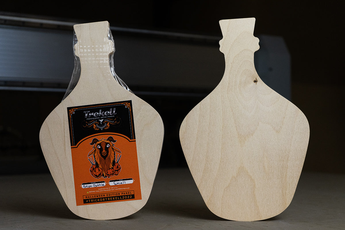 Two unfinished wooden painting panels shaped like potion bottles, with Trekell labels.