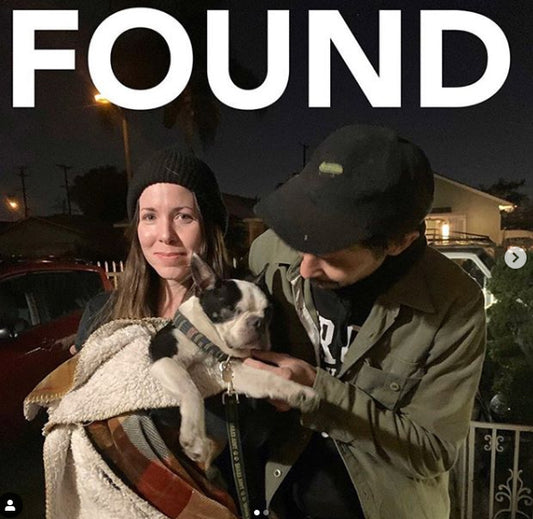 Found poster showing two people holding a small black-and-white dog.