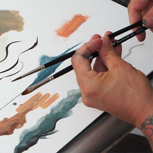 Hands demonstrate two brush tips over black, blue and orange sample strokes.