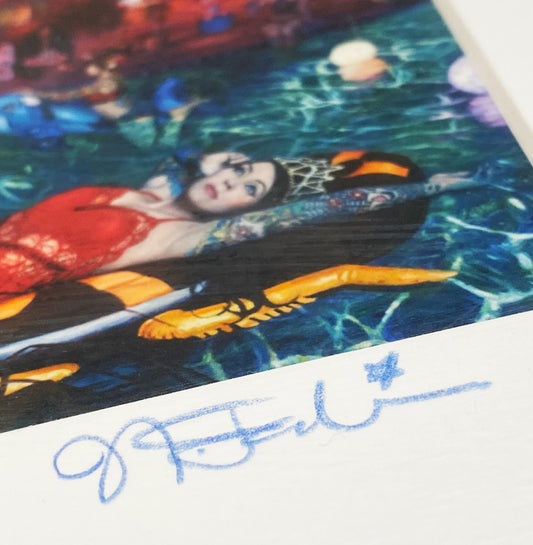 Close-up of a colorful artwork's lower edge with a handwritten signature.