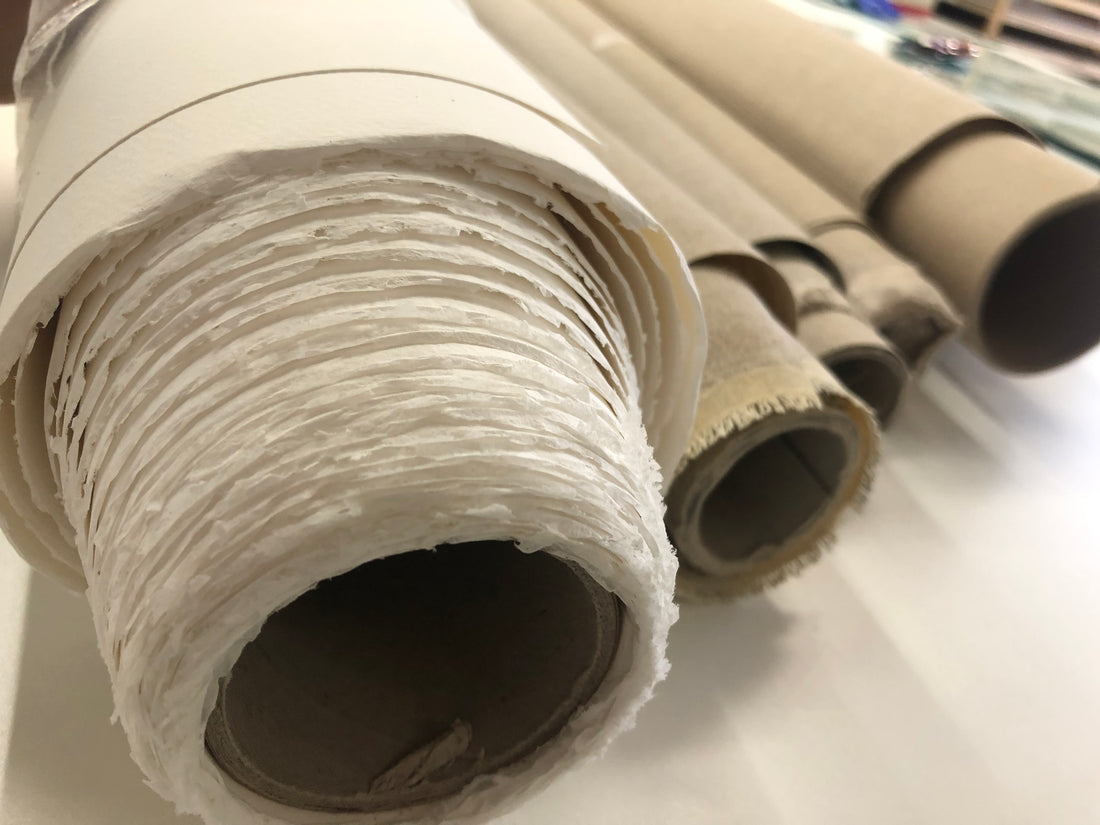 Close-up of coarse fabric rolled around a cardboard tube.