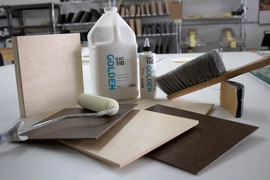 Jug, roller, brush and assorted square panels on a workshop surface.