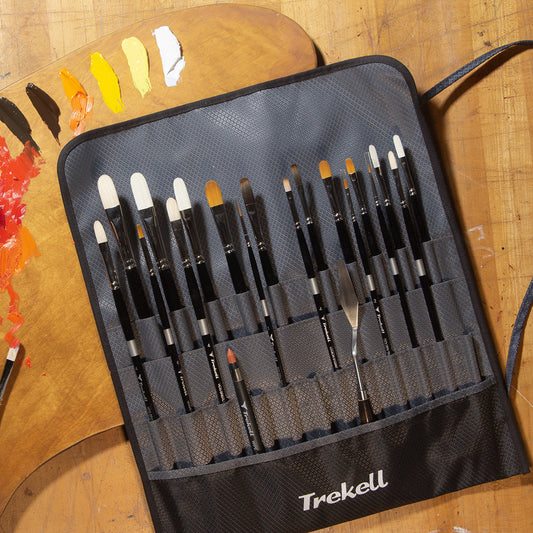 Open black Trekell brush case beside a paint-covered wooden palette.