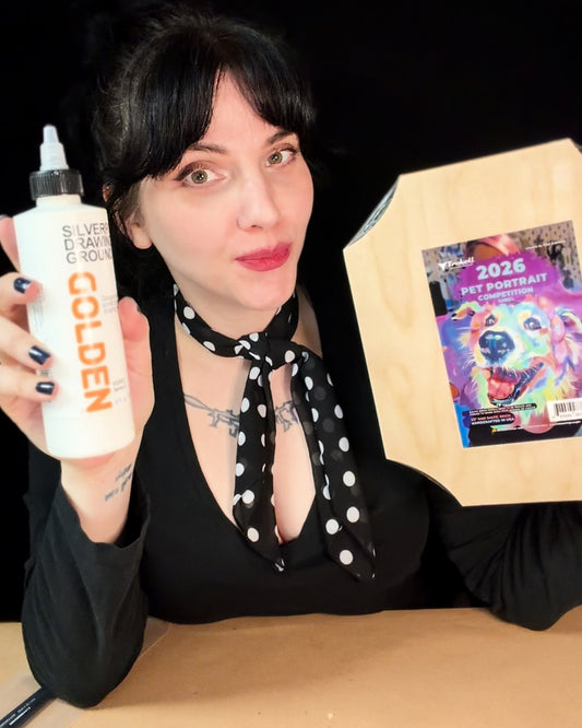 Dark-haired person holds a white bottle beside a colorful small painting.