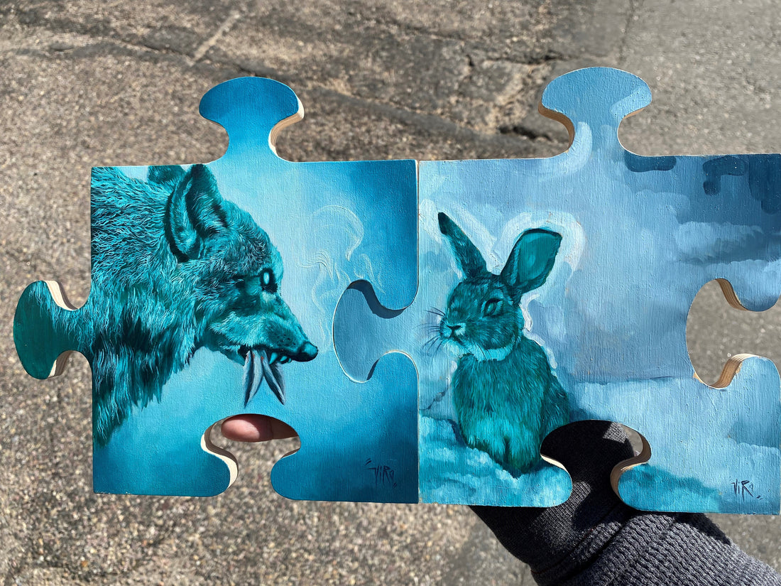 Two joined puzzle-piece panels painted in blue tones: a snarling wolf on the left faces a rabbit on the right.