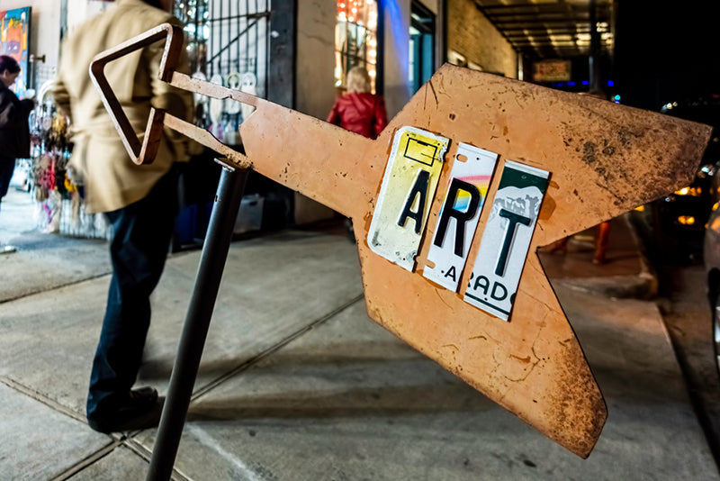 Wooden Art sign with colorful letters at an outdoor display.