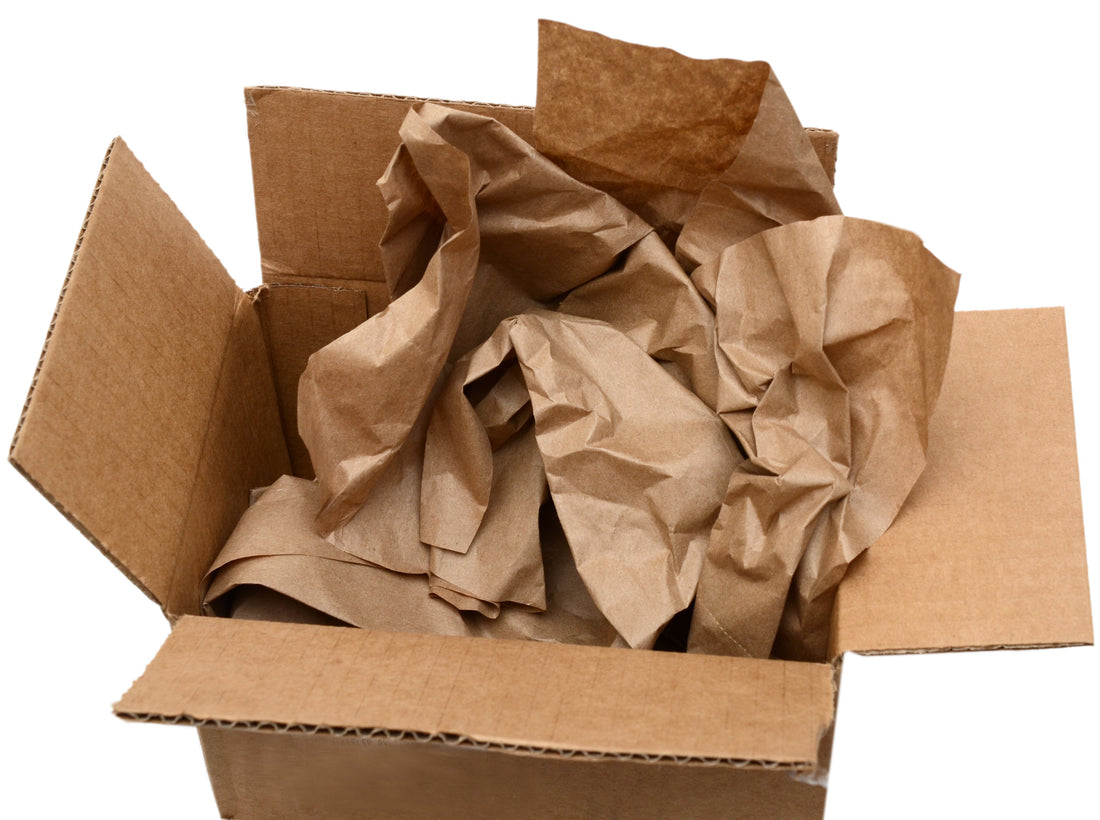 Open cardboard box filled with crumpled brown packing paper.