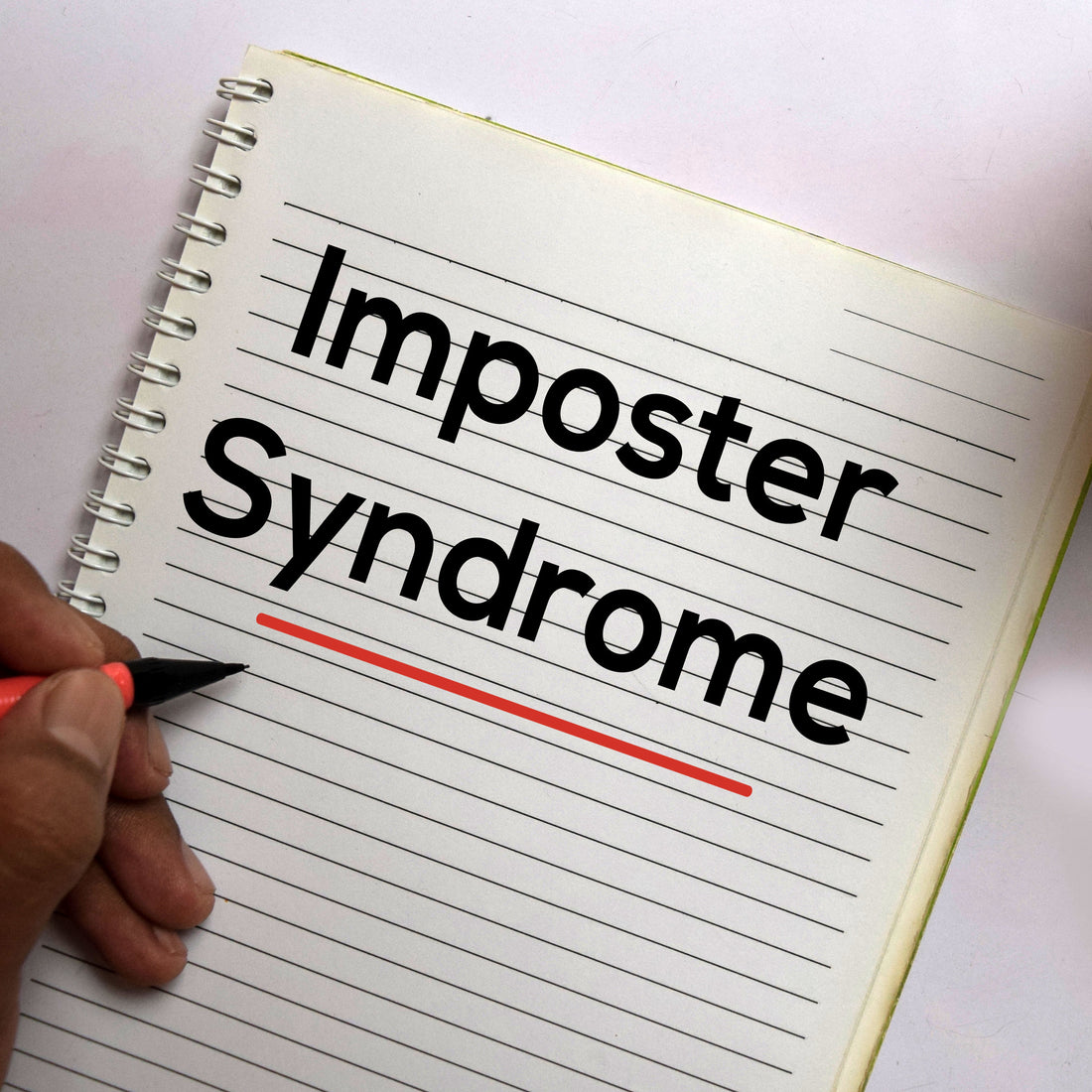 Notebook reads Imposter Syndrome in large black lettering.