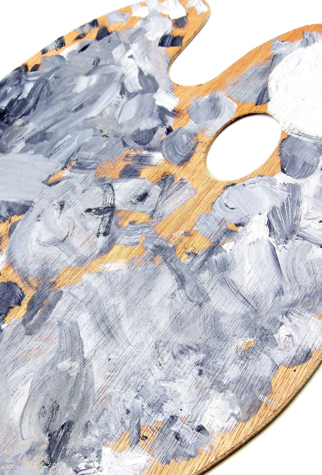 Hand squeezes orange paint onto a gray-and-orange paint-covered palette.