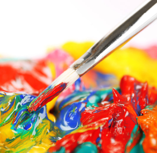 Brush drags colorful paint across a heavily textured palette.