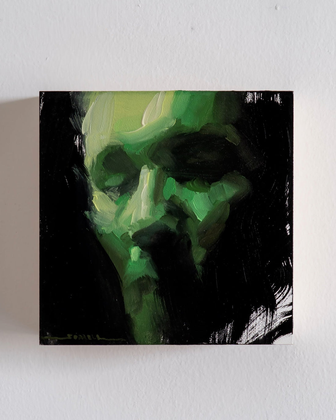 Green-lit skull portrait against black.