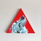 White-and-blue bear head painted on a red triangular panel.