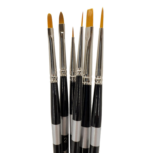 Six black-handled brushes fanned upright with long golden pointed and flat tips.