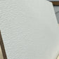 Close-up of a white primed panel showing its textured surface and straight edge.