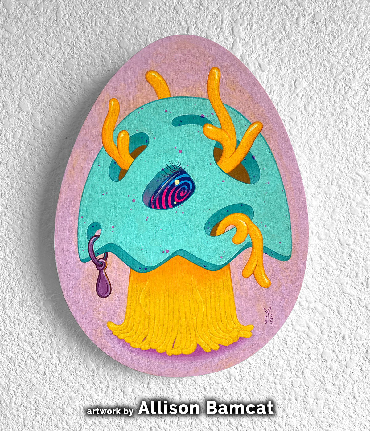 Turquoise creature with orange antlers and a yellow beard painted on a pink egg-shaped panel.