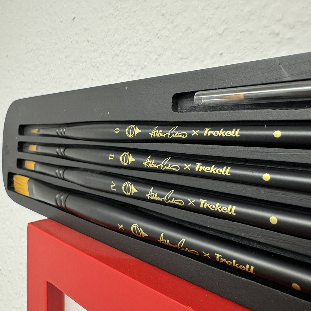Andrew Cadima brushes nestled in black foam, with gold lettering on the black handles.