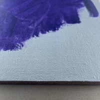 Close-up of textured pale linen with a purple brushstroke.