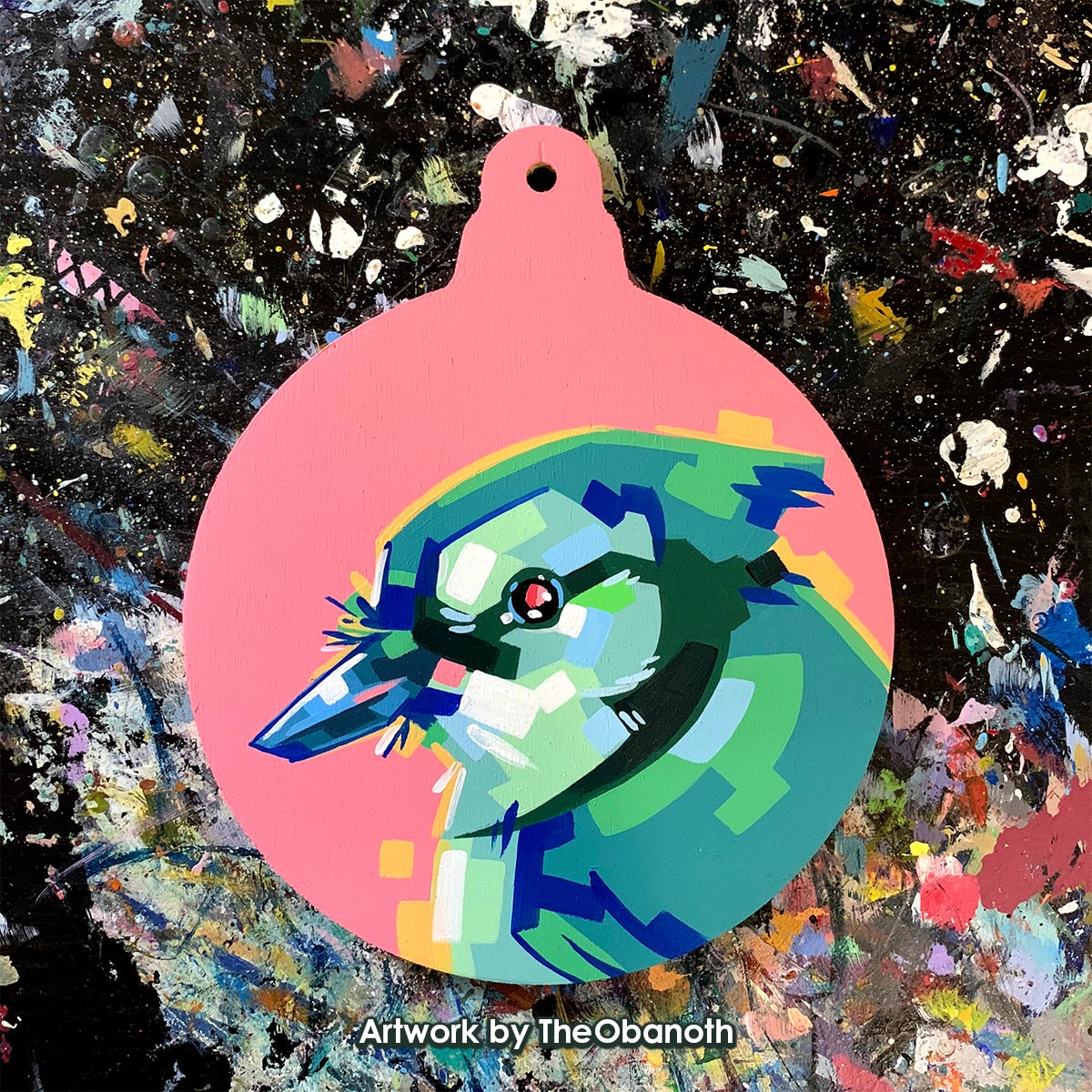 Faceted blue-and-green bird head painted on a pink round ornament panel.