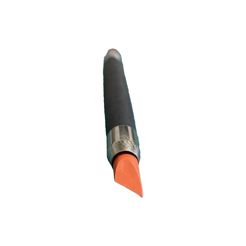 Close-up of the angled orange end of a dark-handled double-ended brush.