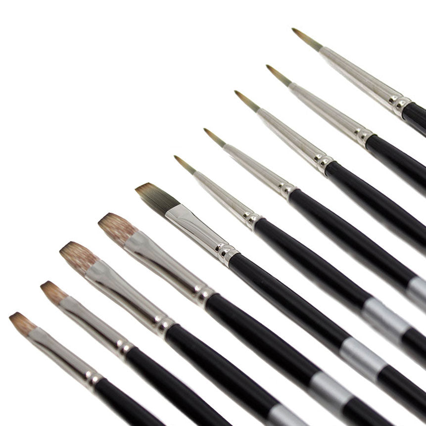 Black-handled brushes fanned diagonally with pale pointed and brown flat bristles.