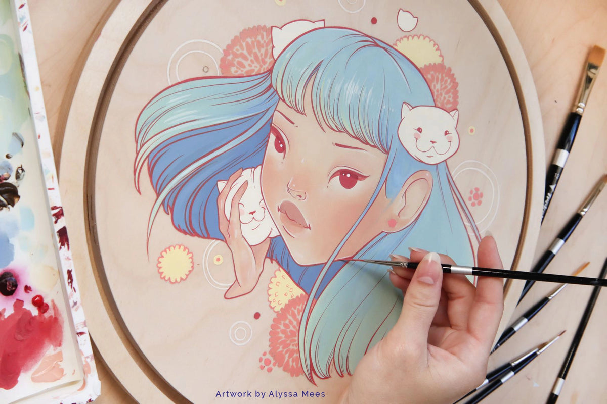 Hand paints a pastel blue-haired woman's portrait on a round panel beside brushes and paint containers.