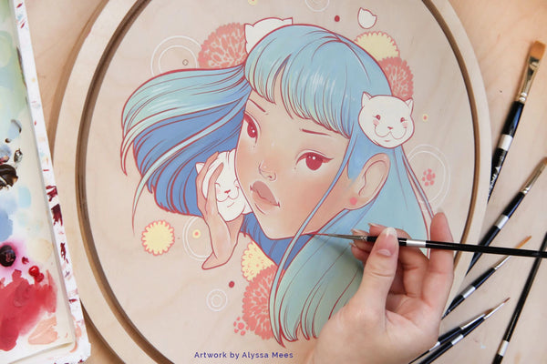 Hand paints a pastel blue-haired woman's portrait on a round panel beside brushes and paint containers.