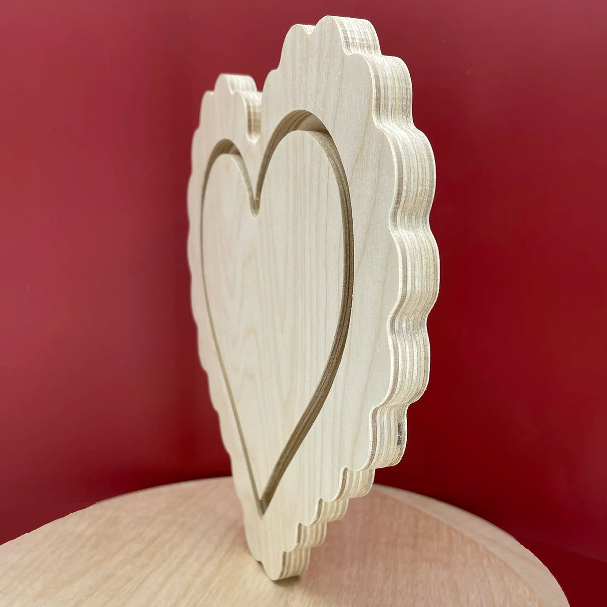 Scalloped heart floater panel, angled side view showing the recessed heart and layered thickness.