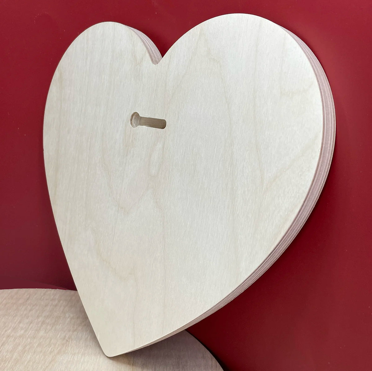 Symbolic heart panel angled back view showing its keyhole slot and wooden thickness.