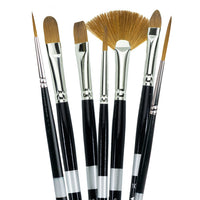 Seven black-handled brushes fanned upright with pale and golden flat, pointed and fan-shaped bristles.