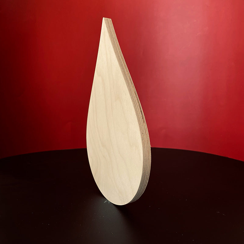 Trekell Rain Drop Panel standing on edge against red, showing its wooden thickness.
